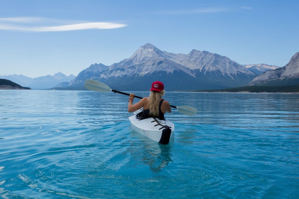 綺麗な湖でカヌーを漕ぐ女性