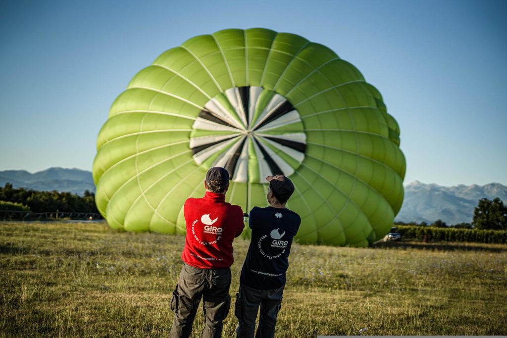 膨らみかかった気球を引っ張る男性2人