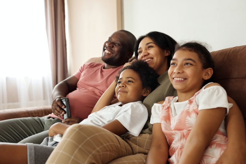 テレビを見て笑っている家族