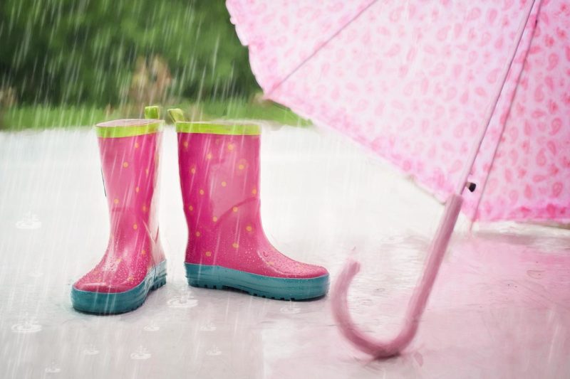 雨に濡れるピンクの長靴と傘