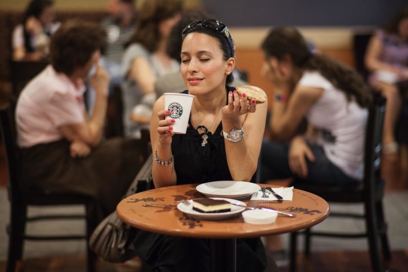 スタバでコーヒーを飲み、ケーキを食べる女性