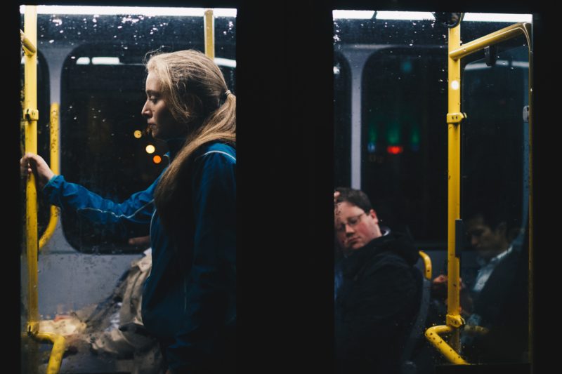 雨の中でバスにのり立っている女性