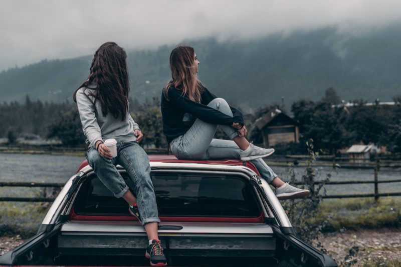 車の屋根に座る二人の女性
