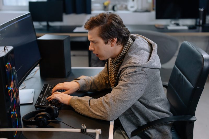 暗い会社でパソコンをする男性