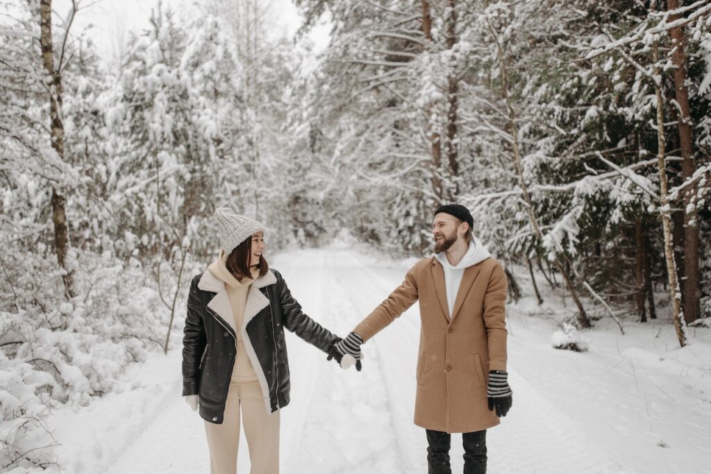 雪山の道で離れて手を繋ぐカップル