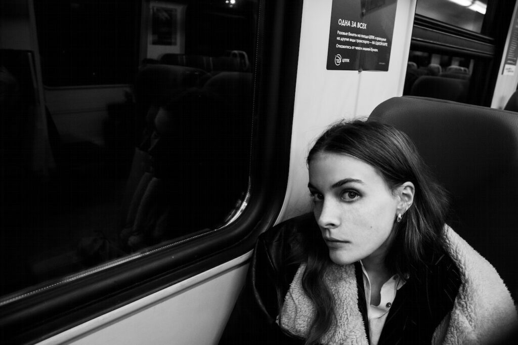 電車に座っている女性の白黒写真