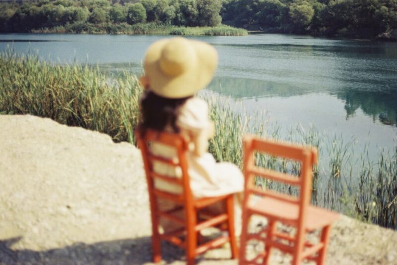 湖畔でイスに座って佇んでいる女の子